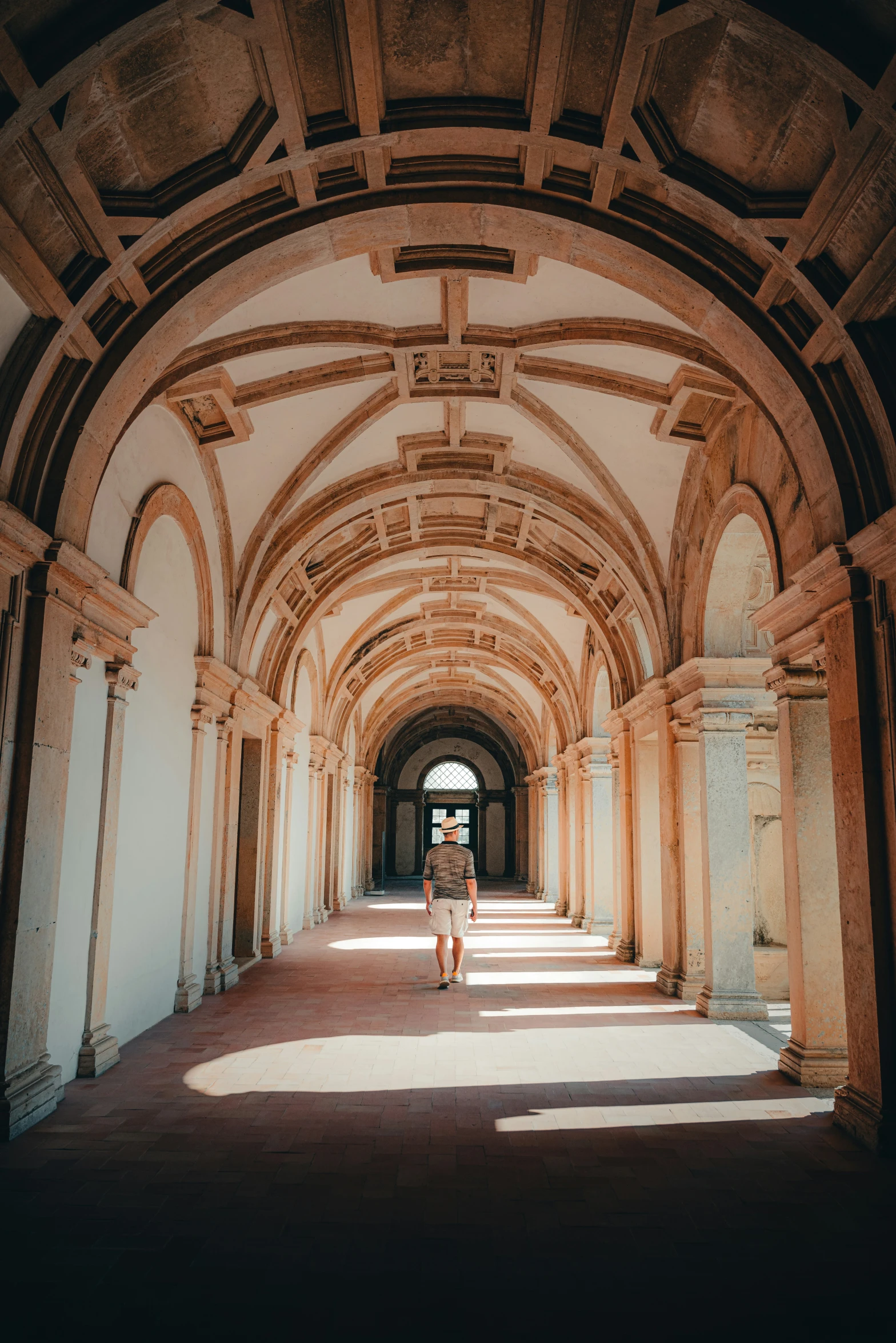 a person sitting in an old building covered by stone archways