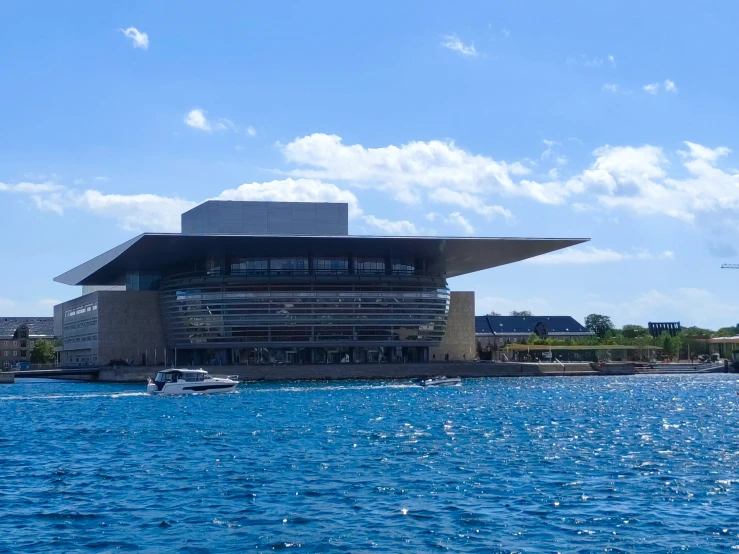 a building sits next to a body of water with several boats out front