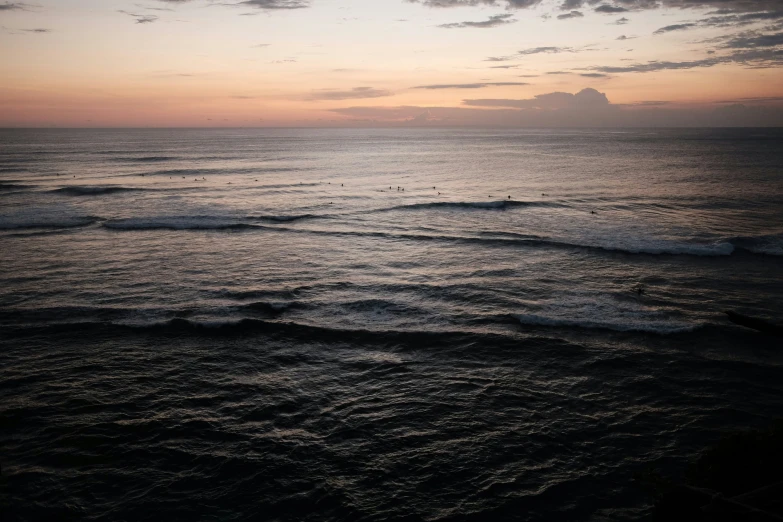 the sun set at the ocean with waves