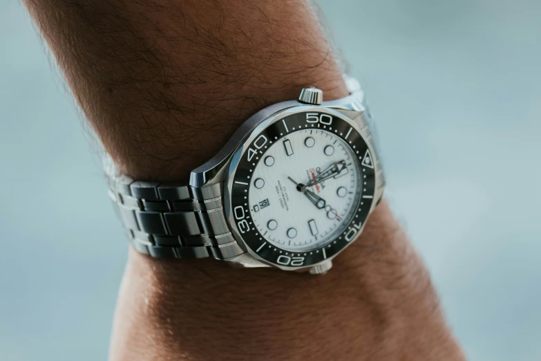 a person wearing a watch with two hands and the watch has black and white dials