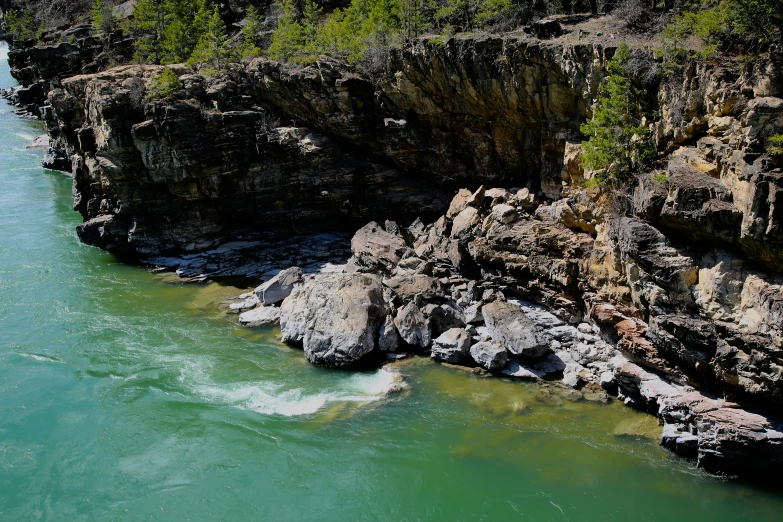 the river has blue green water next to some rocks