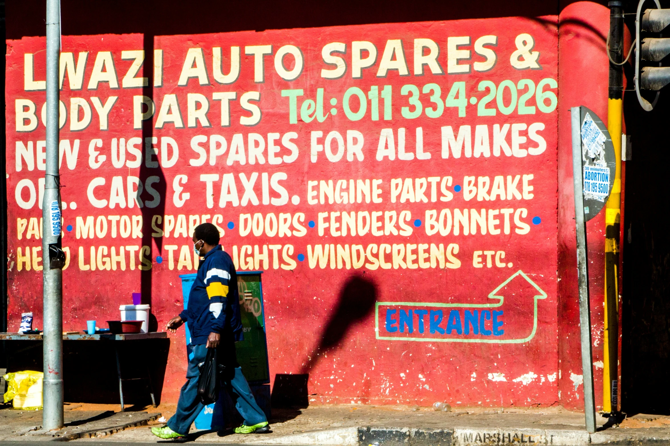 two young people walking past an advertit for auto parts