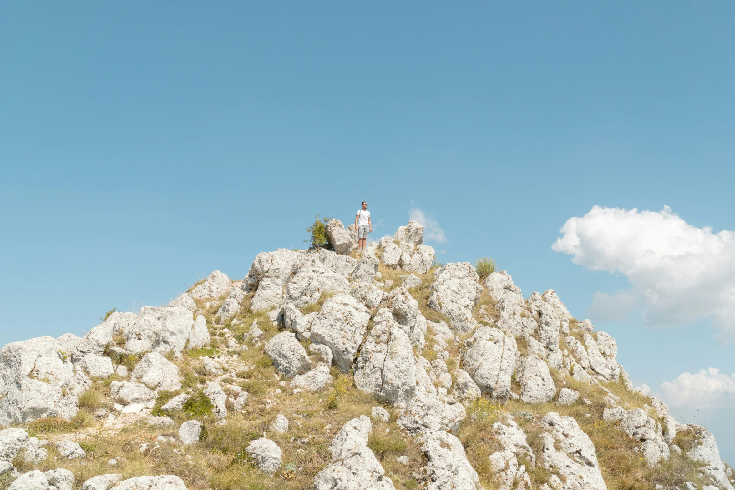 a person on the top of a hill, standing alone