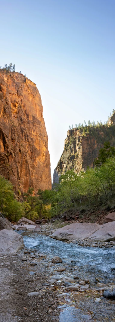 a small creek in between the cliffs of a mountain