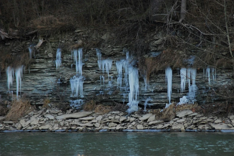 icicles hang on the rocks near a body of water