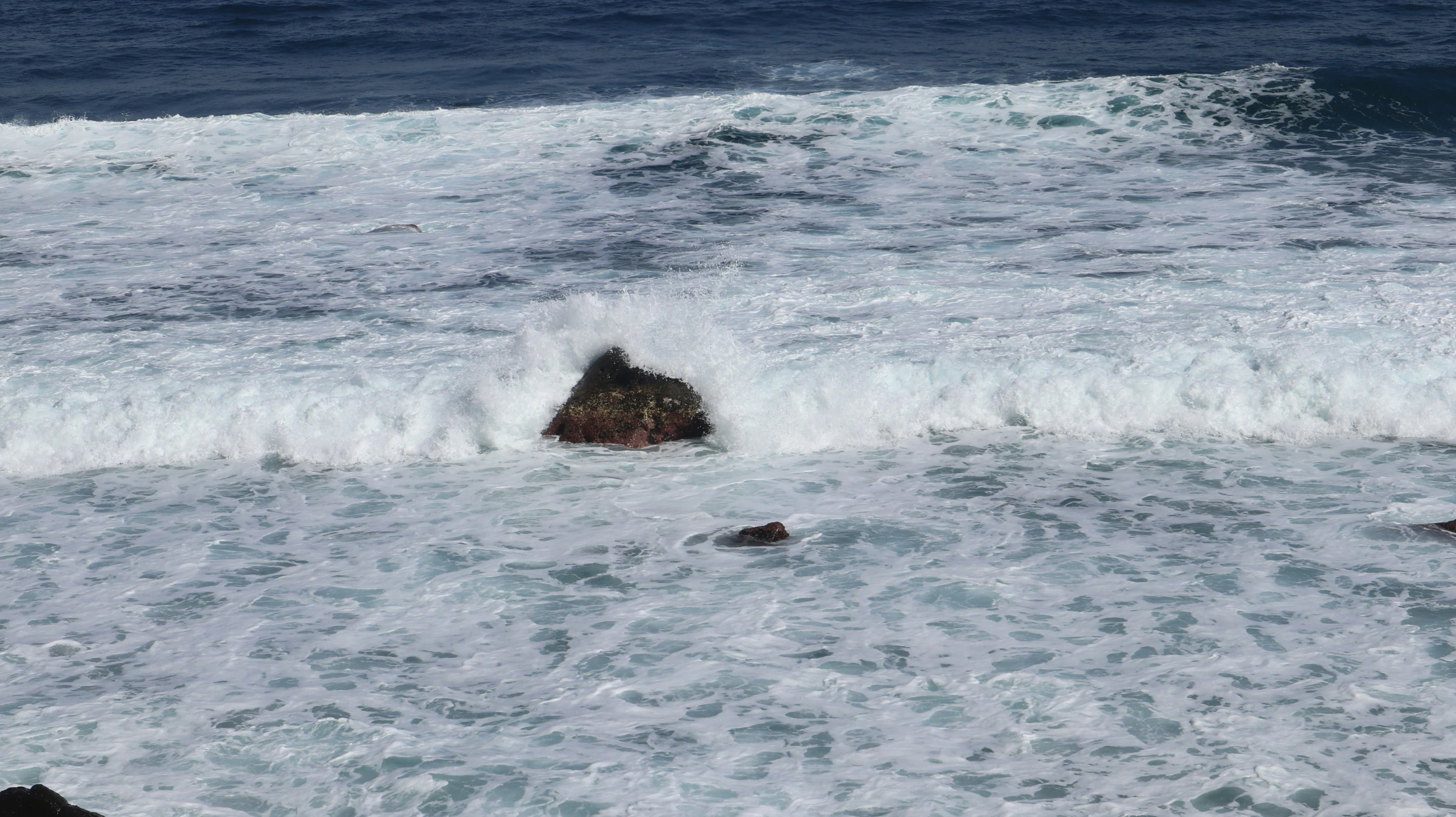 a couple of rocks in the middle of the ocean