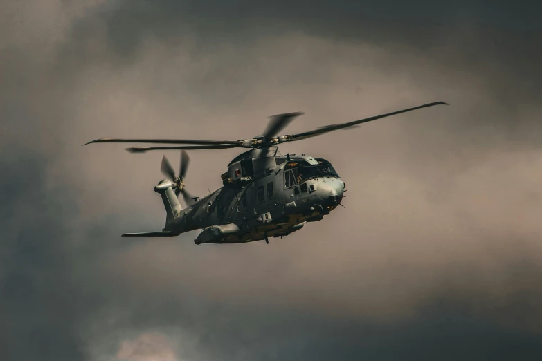 a large military airplane flying through a cloudy sky