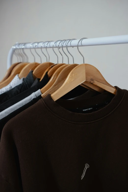 an un - made brown shirt is hanging from a hanger