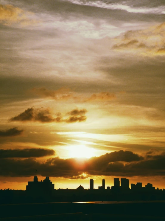 the sun setting behind clouds in the sky