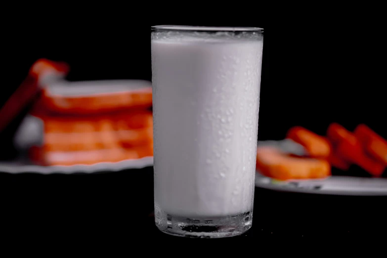 a glass and plate filled with food on top of a table