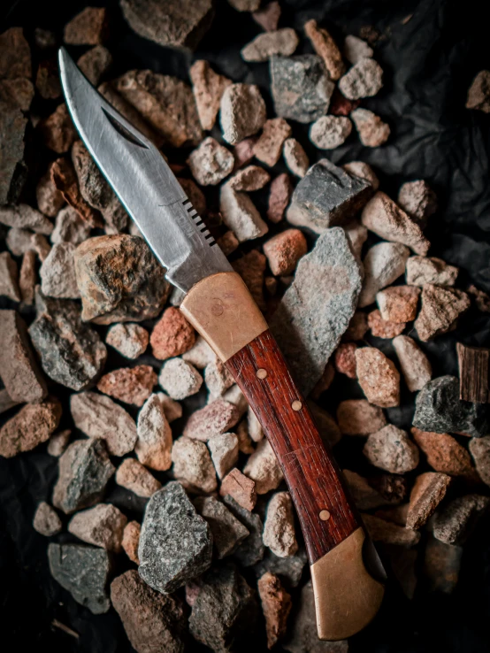 a knife on top of some rocks on the ground