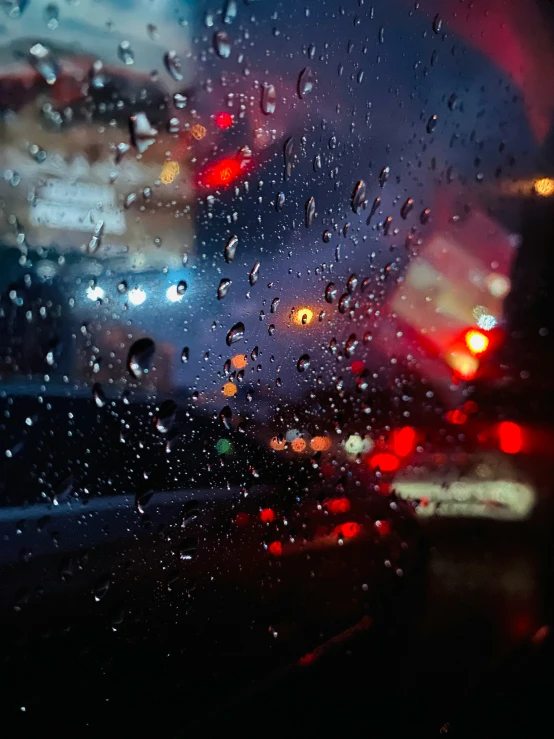 traffic in the rain outside a windshield with rain drops