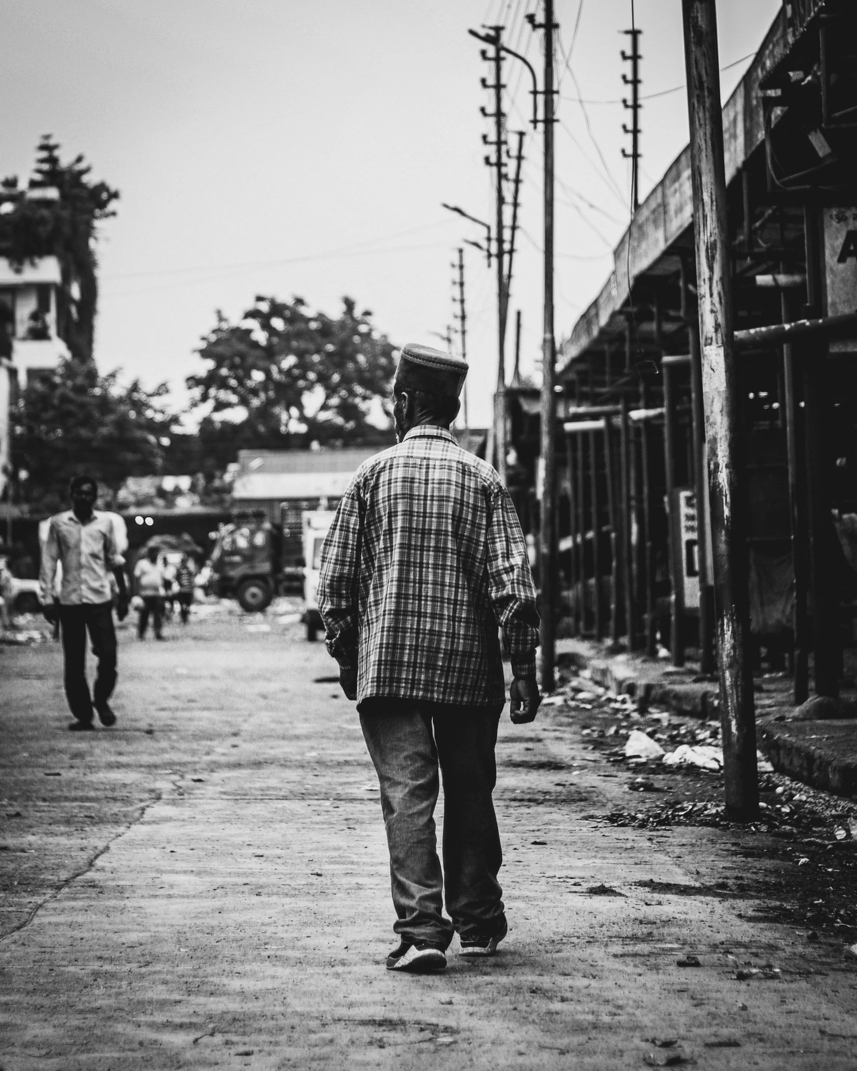 black and white pograph of man walking on sidewalk