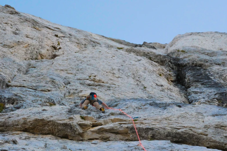 the climber is attempting to reach a high cliff