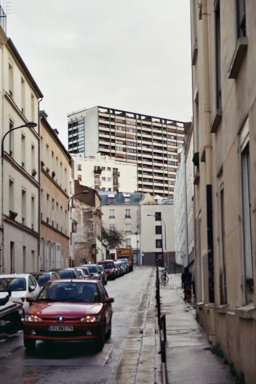 the view down an alley with some cars parked along it