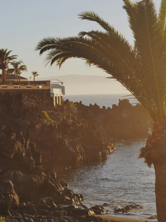 an ocean cliff near a shore with houses on it