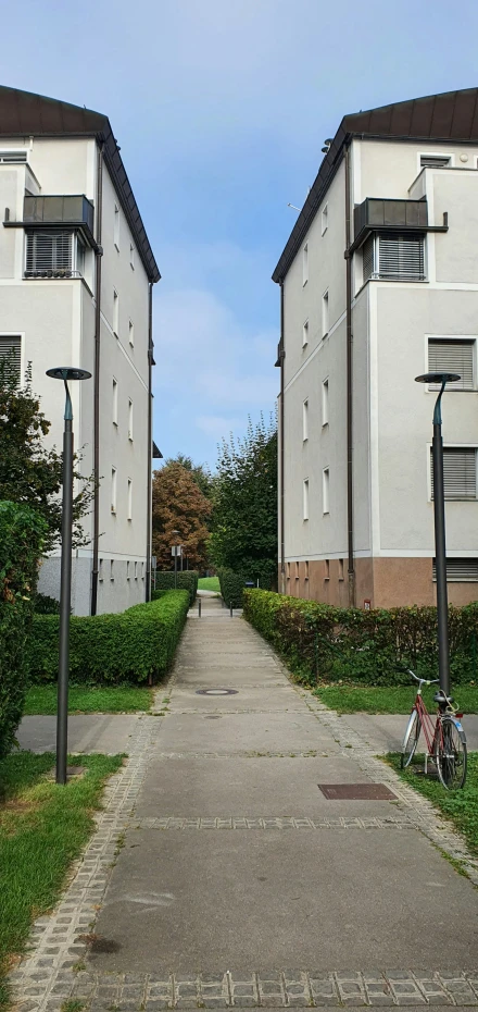 two buildings in the distance with a bicycle parked on a path between them