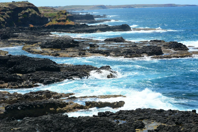 a bunch of rocks on the coast with water and water