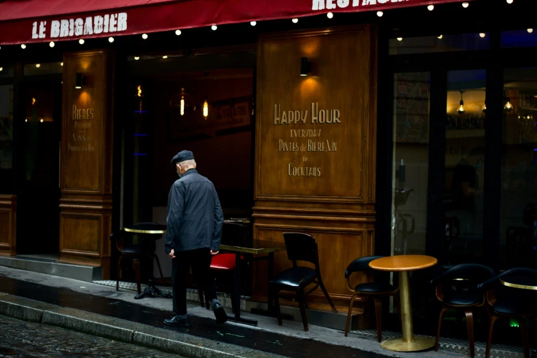 a man standing outside of a restaurant with a table in front