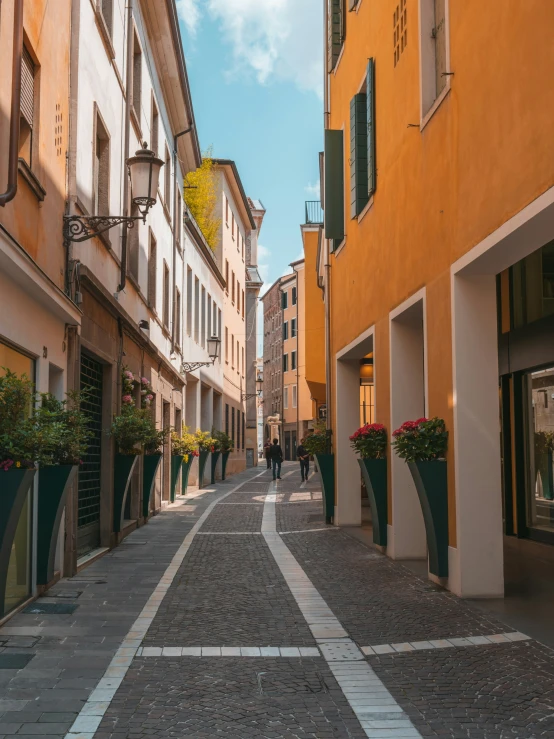 a narrow cobble stone street with buildings lining the side