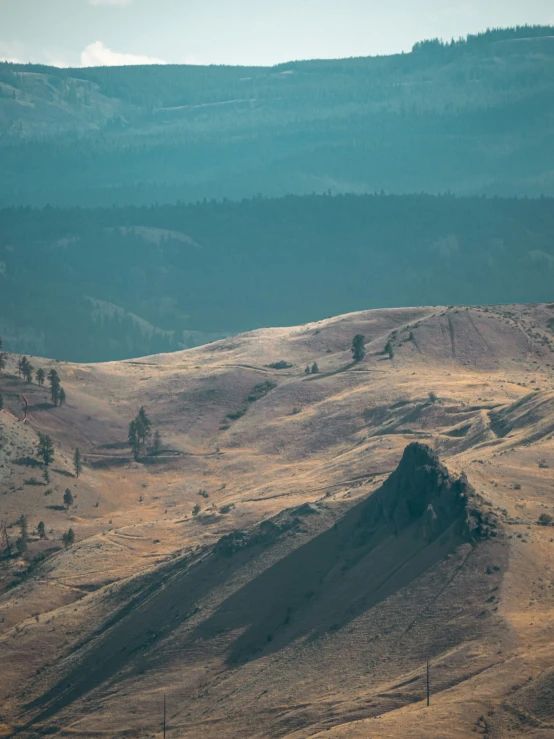 a large mountain range with a hill in the distance