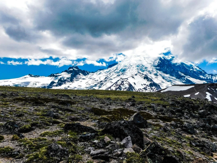 a view of some mountains under cloudy skies