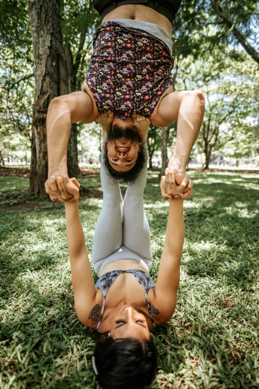 two people standing on one leg while upside down