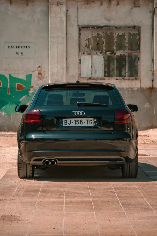 a grey car parked in front of a cement building