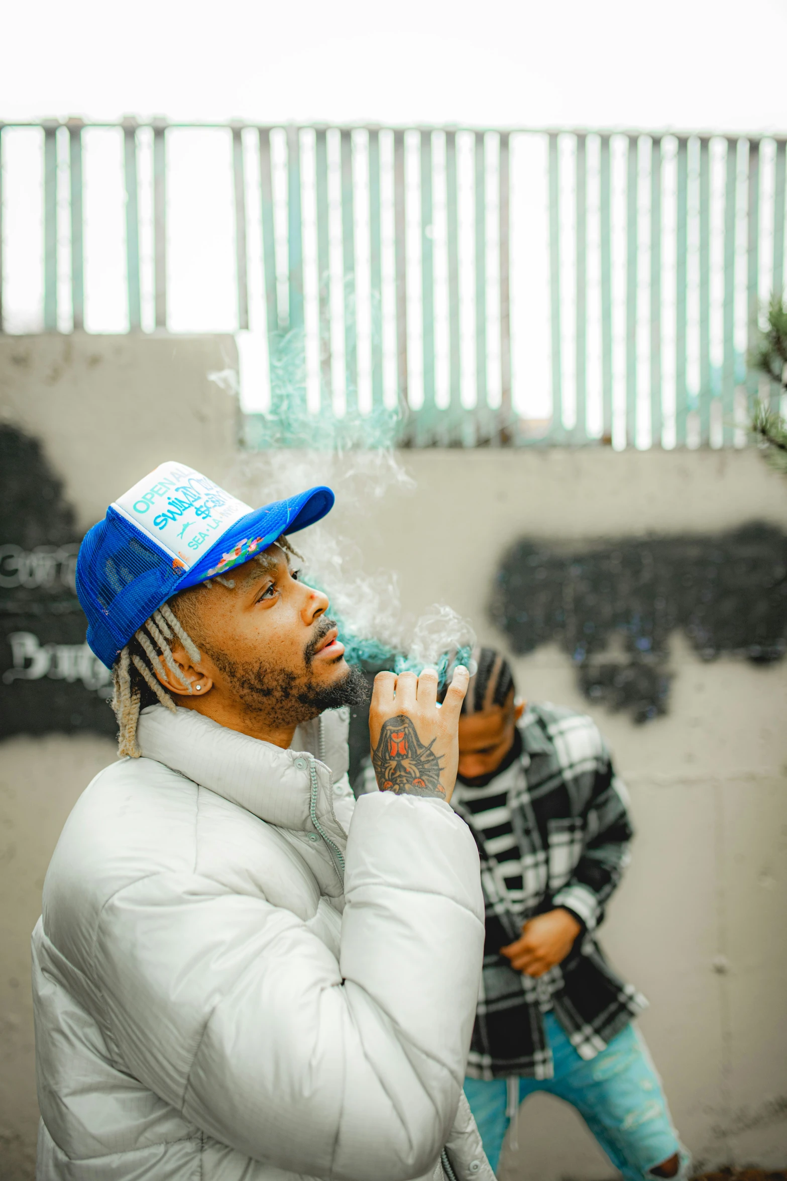 a young man with a hat smoking a cigarette