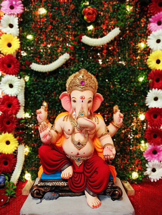 an ornate statue of lord ganesh with flowers surrounding it