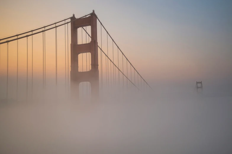 fog covers the golden gate bridge in the san francisco mountains