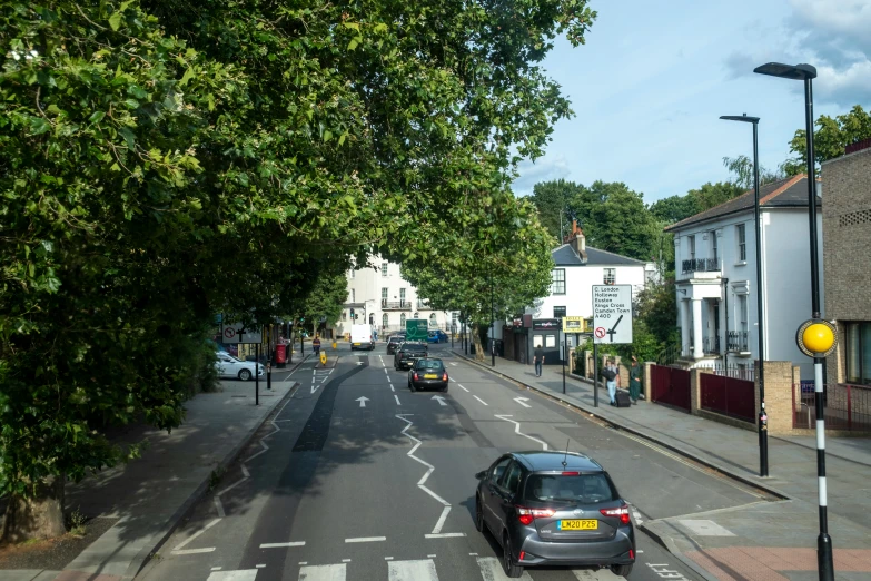 cars driving on the road in front of some buildings