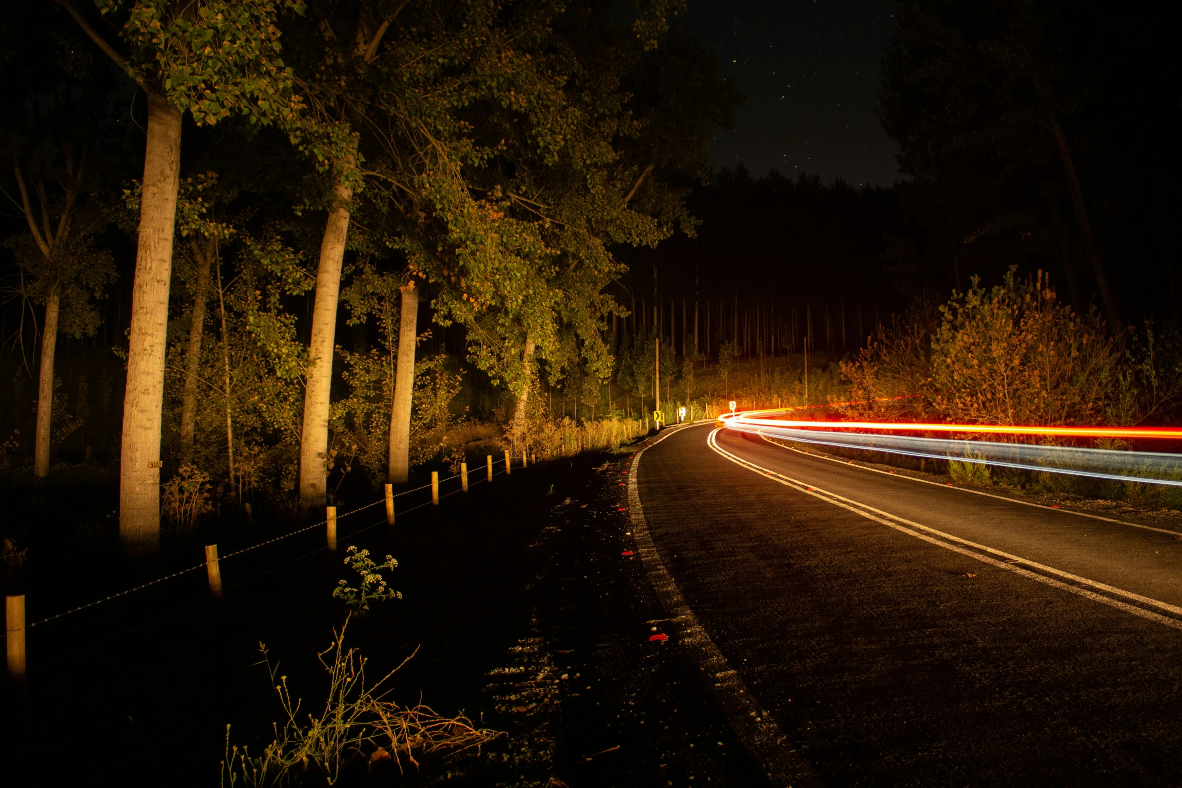 a car is driving down the road at night