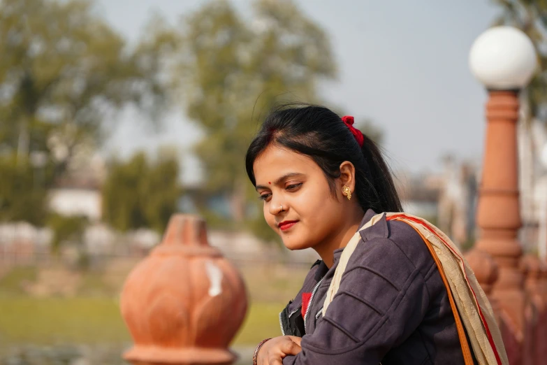 an indian woman looks down at her phone