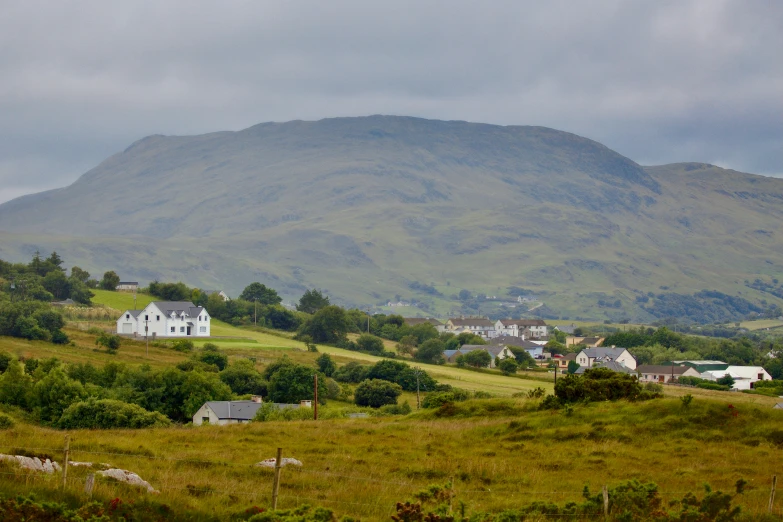 an image of a mountain town with green grass