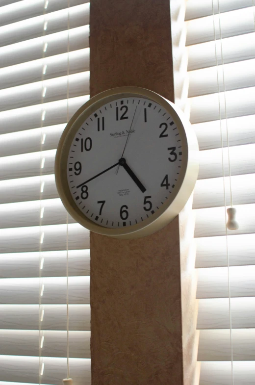 clock on the wall near window blinds with white blinds
