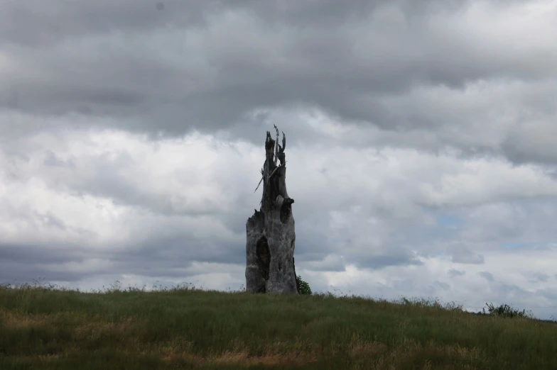 an unusual rock building on top of a grassy hill