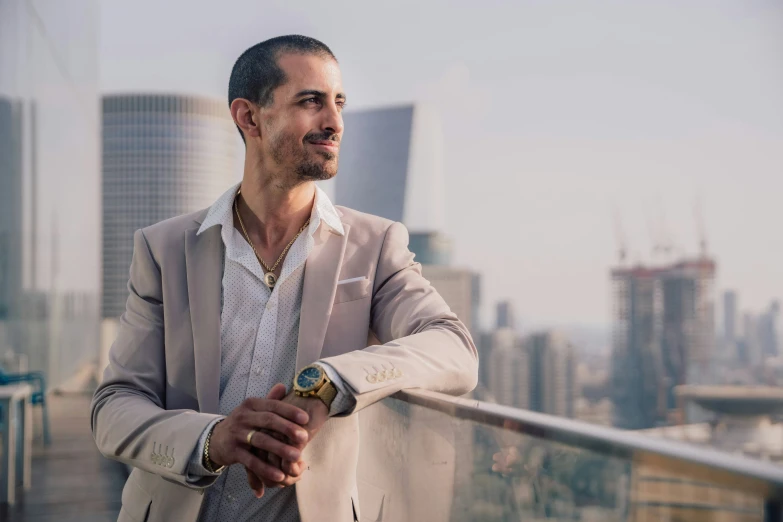 a man in a suit looks off into the distance with his arms crossed