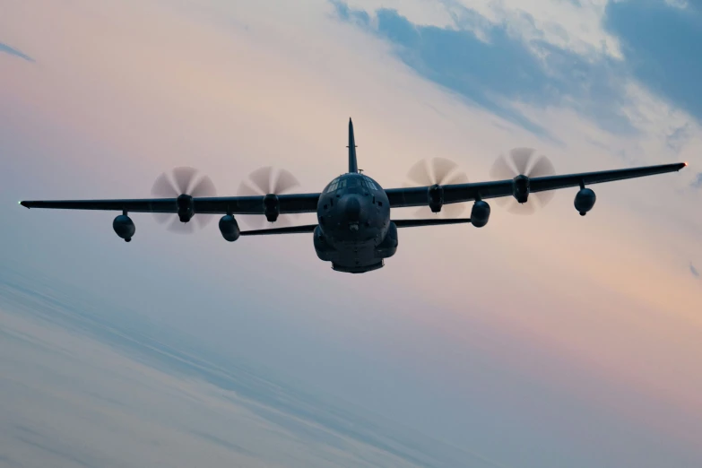 an airplane flies under a sunset and clouds