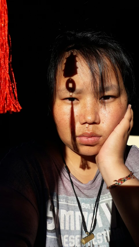 a woman wearing a necklace with a shadow on her face