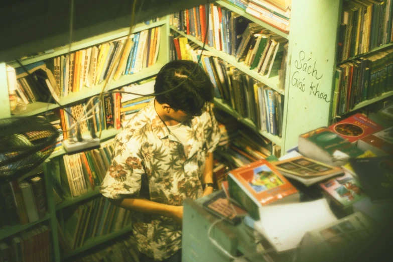 the woman is leaning on the bookshelf to read