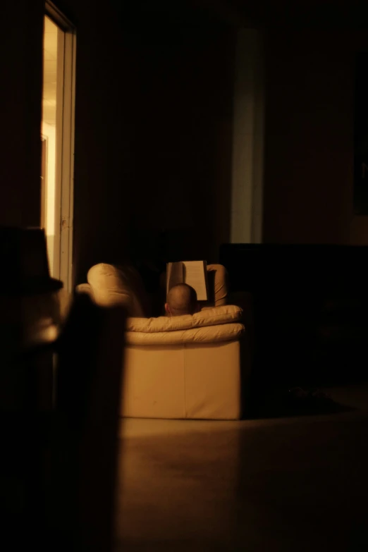 a baby sleeping on an unmade couch in a dark room