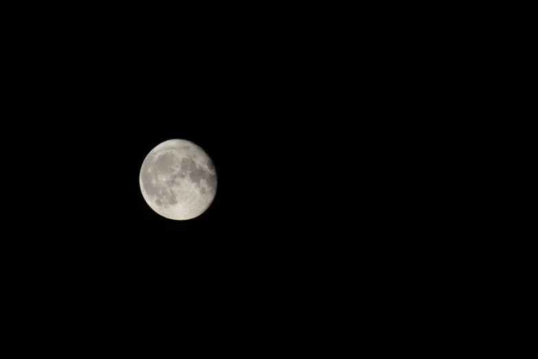 the full moon is shining bright against the black sky