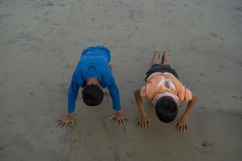 two people are doing h ups in the sand