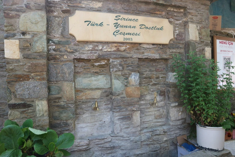 sign on stone wall saying forest gardens, decorated