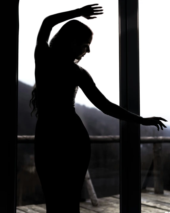 a woman is standing in a doorway by a window