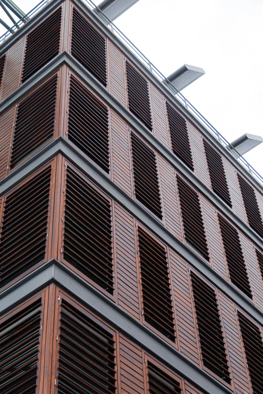 the corner of a brick building that is made of vertical blinds