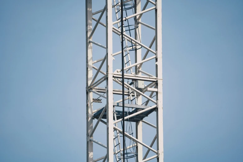 a tall white tower structure next to a blue sky