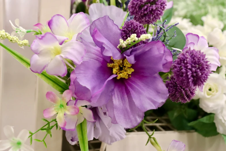 purple flowers sitting inside of a vase on top of a table