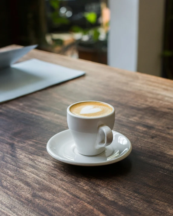 a coffee cup is on a saucer on a wooden table